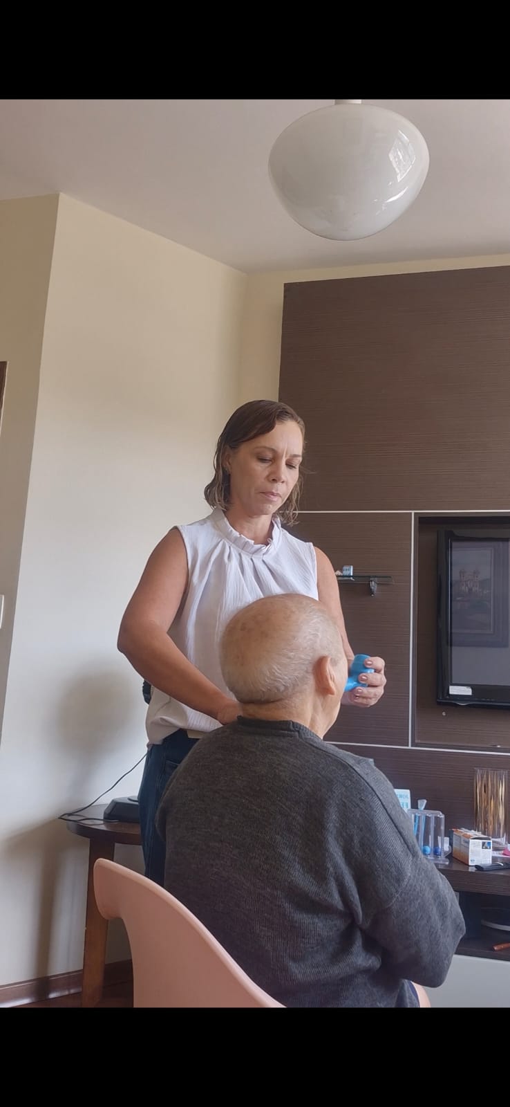 Elisângela em atendimento fonoaudiológico com paciente idoso